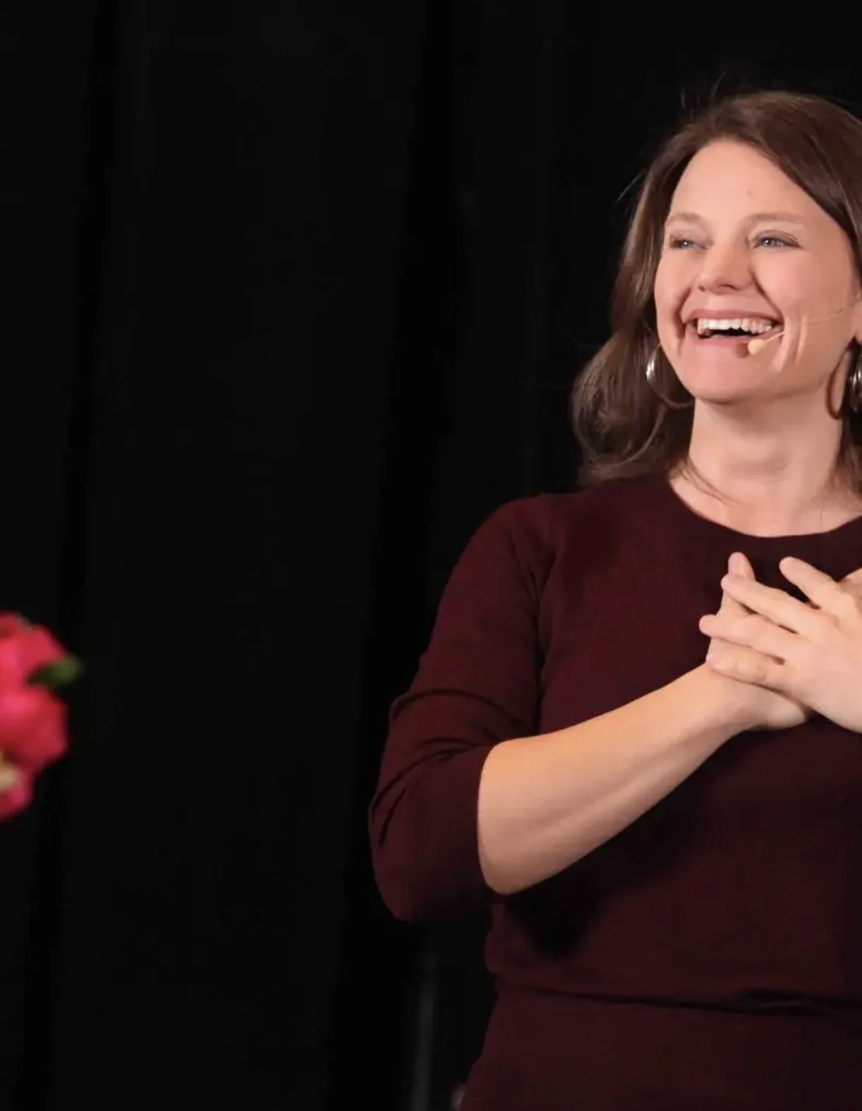 Callan Rush laughing on stage with her hands on her heart