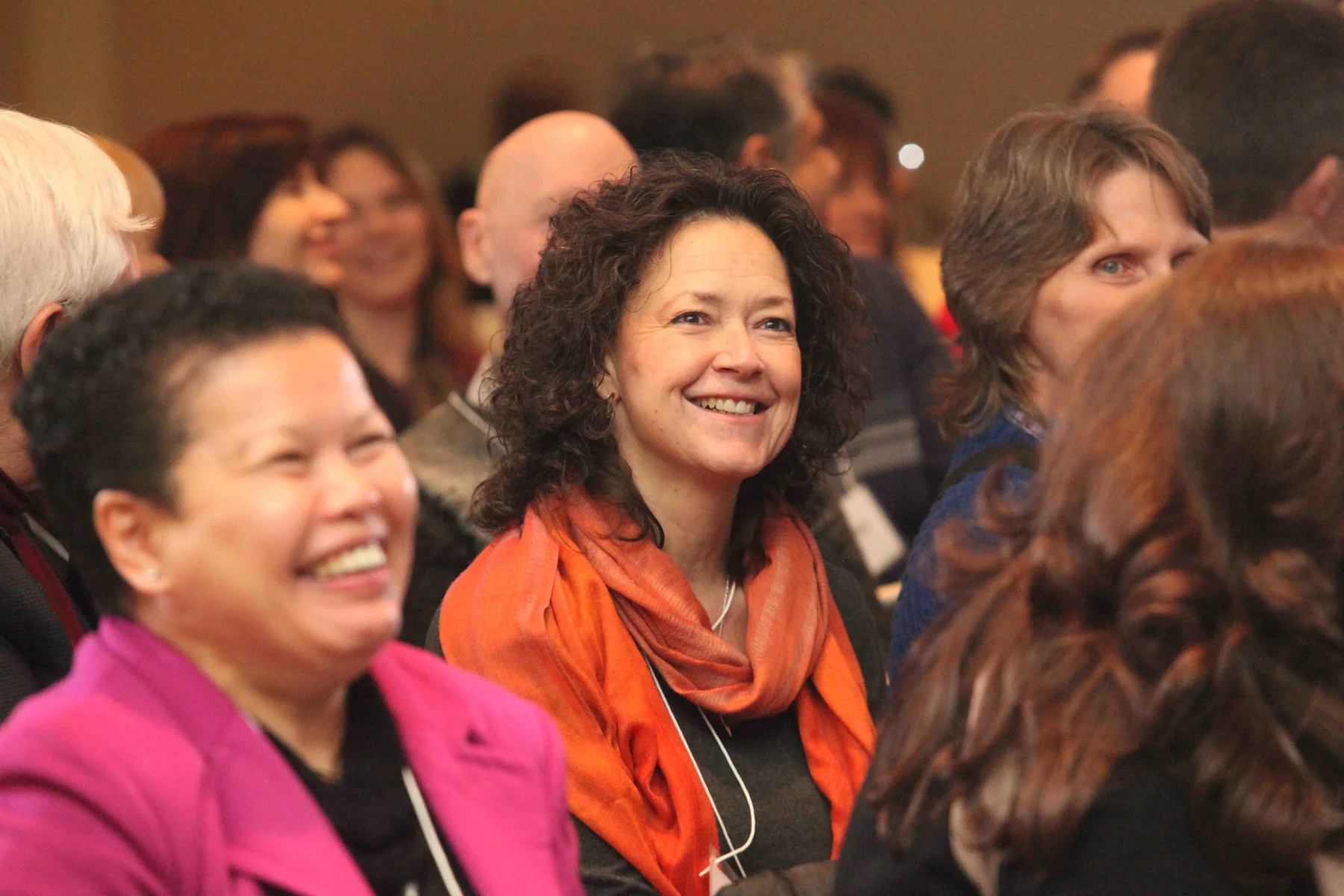 Workshop participants laughing together in a full room
